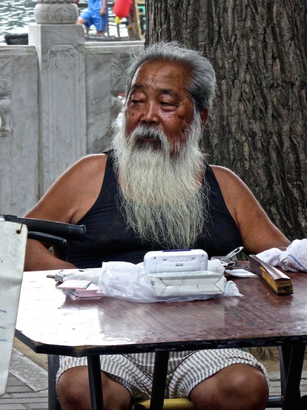 Un vieux monsieur observe le monde dans l'hutong de Nanluoguxiang à Pékin