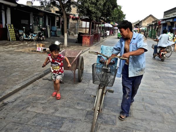 Un petit garçon et son père dans une rue de Pingyao